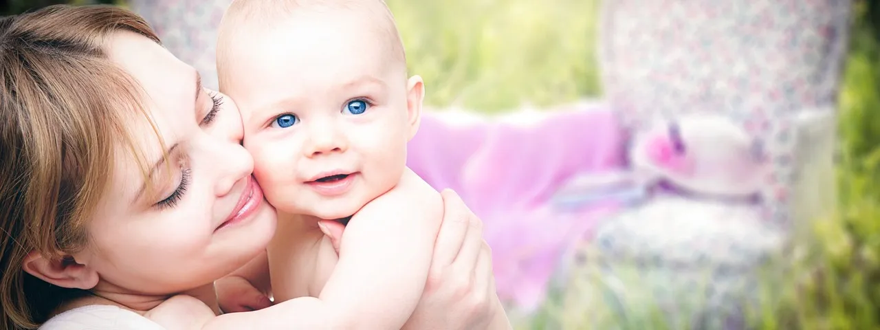 Uśmiechnięta mama z malutkim dzieckiem na rękach