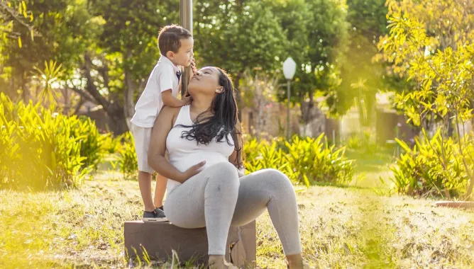 kobieta w ciąży z małym dzieckiem obok